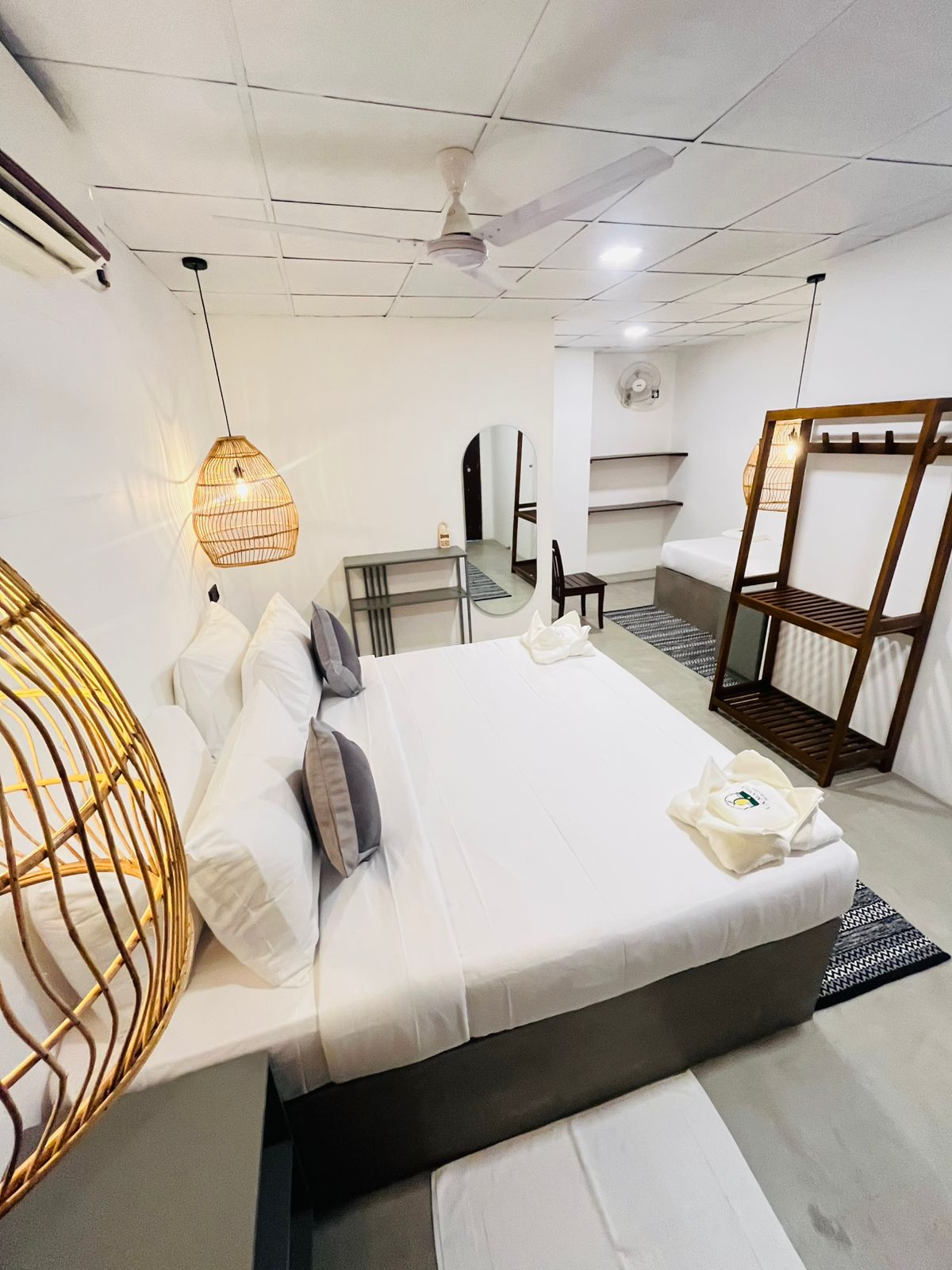 Guest room with double bed, open shelving and full-length mirror at LÁ MANGÁ Mirissa