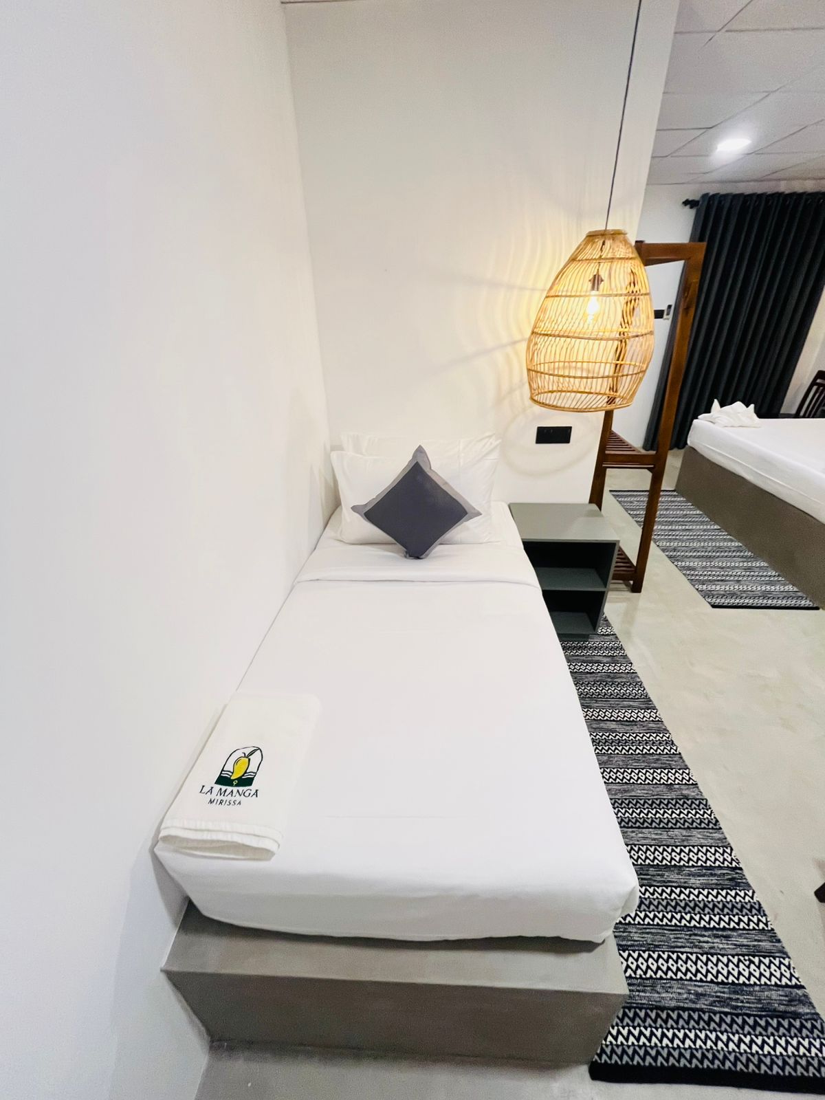 Triple room at LÁ MANGÁ with a single bed beside the double bed and rattan pendant lighting