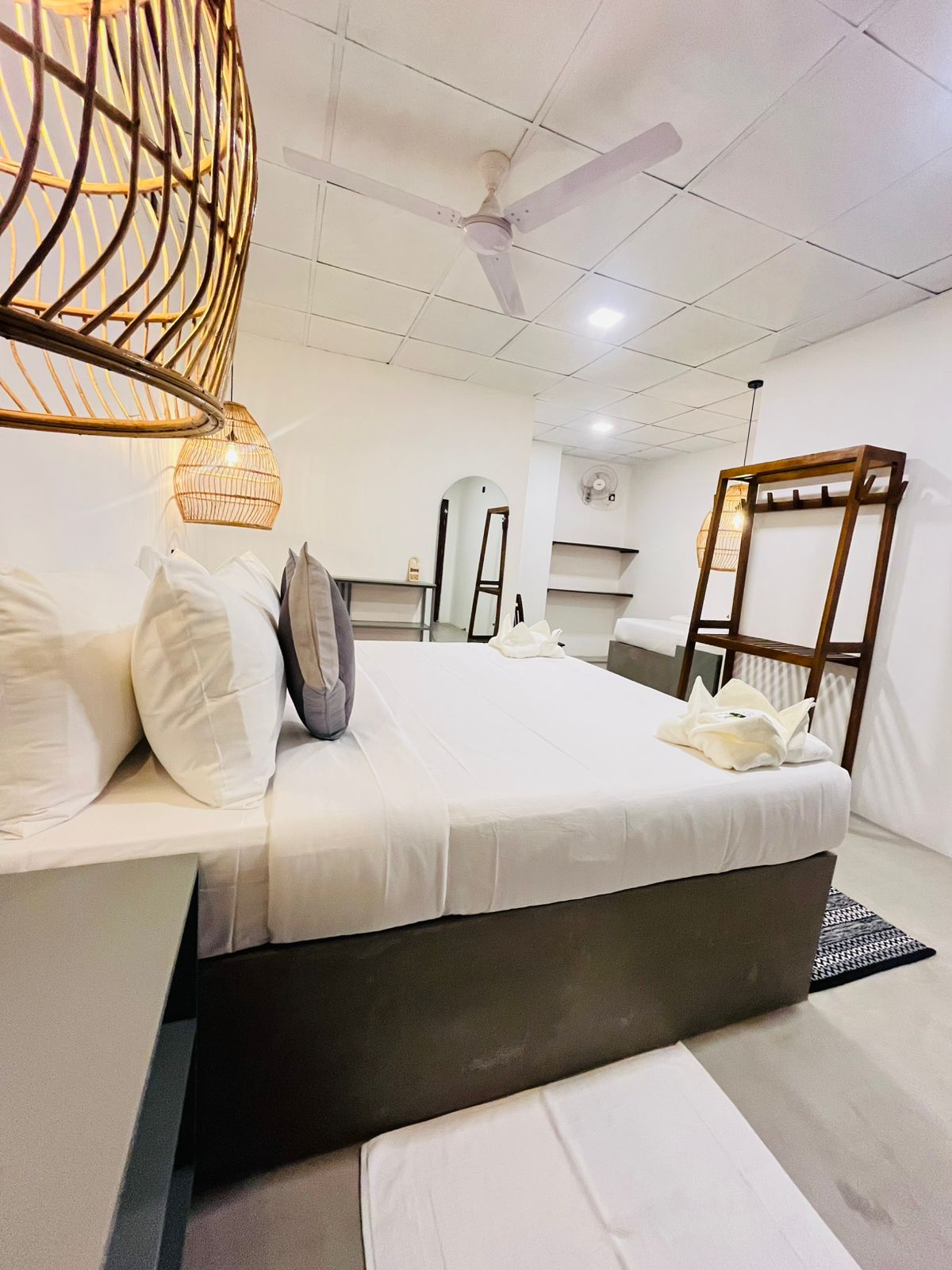 Freshly made double bed with cushions and a carved wooden headboard at LÁ MANGÁ