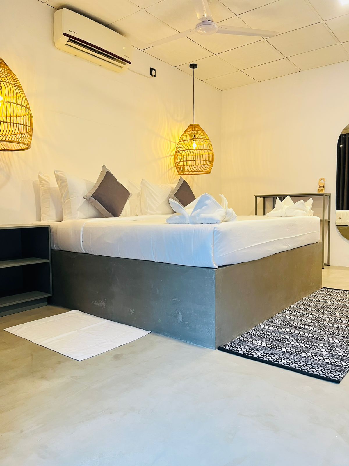 Air-conditioned double room with rattan lighting and a woven floor rug