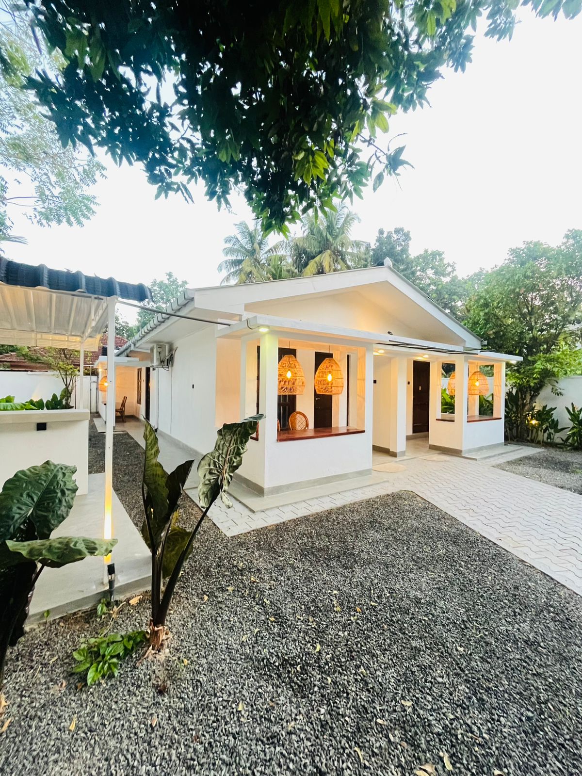 Whitewashed exterior of LÁ MANGÁ set among tropical trees in Udupila, Mirissa