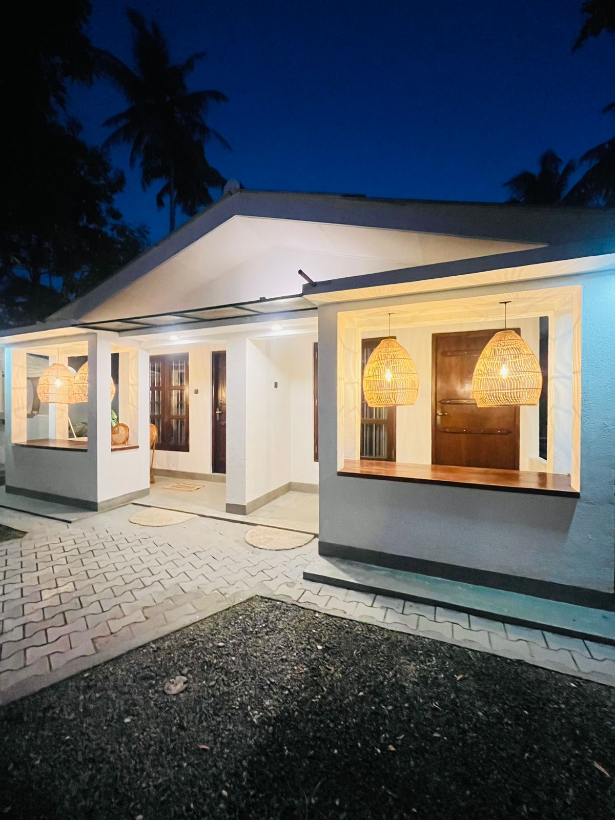 Evening view of the LÁ MANGÁ veranda with warm lighting and tropical planting
