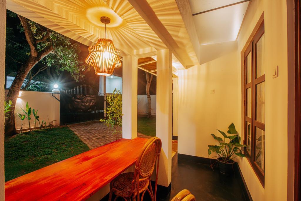 Outdoor dining table under a rattan pendant light in the LÁ MANGÁ garden at night
