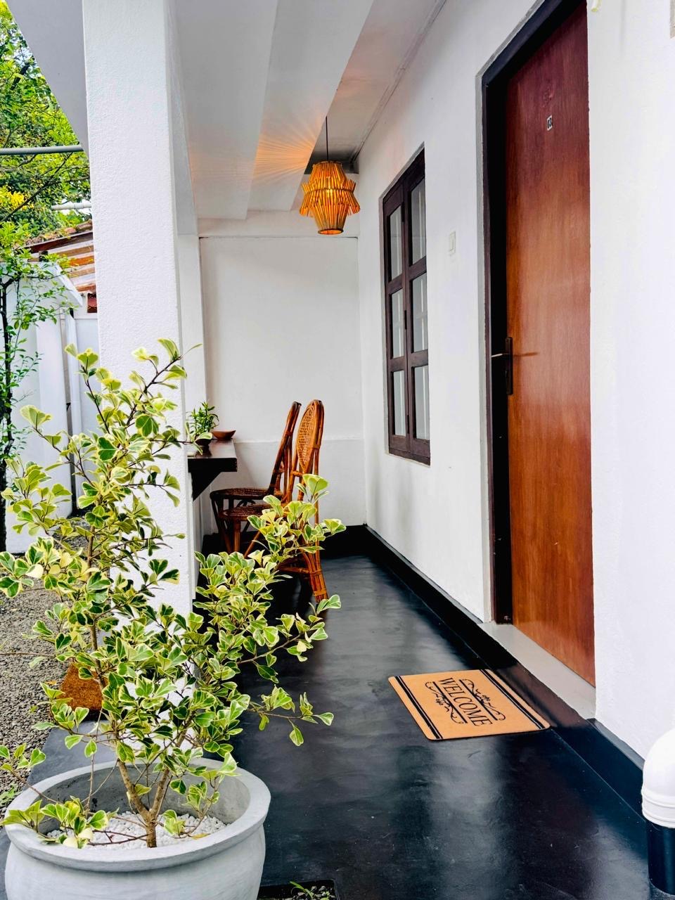 Guest room entrance with a potted plant, polished floor and hanging lantern